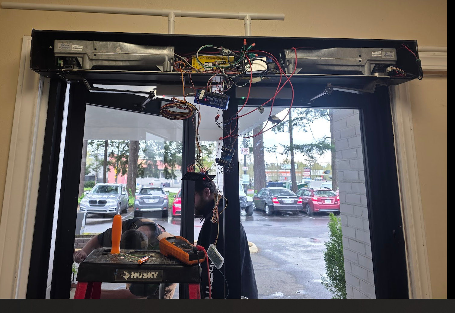 Technicians servicing an automatic double-door operator