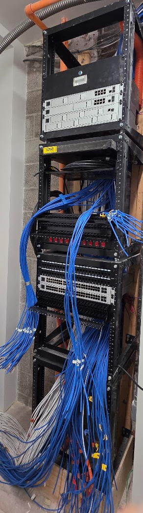 Tall communications rack with blue structured cabling